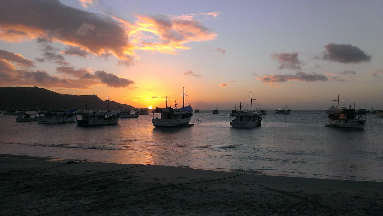 Atardecer sobre la bahía de Juangriego con barcos pesqueros